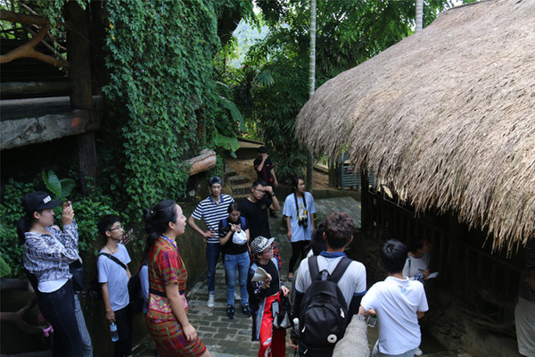 三亚学院师生认真观摩黎族船型屋营造技艺.jpg